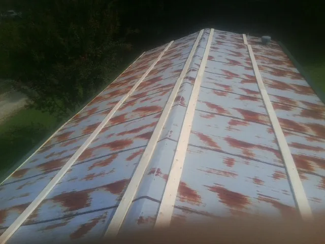 Rusted metal roof panels with new wood purlins before replacement — Storm Damage Roof Repair in Clermont by Roofing Brothers