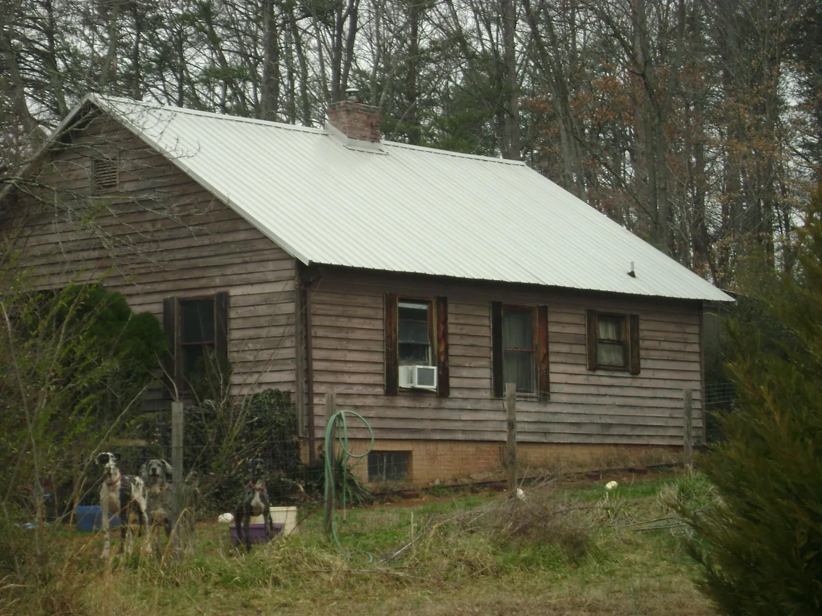 White metal roof on an old wood sided farmhouse, from a Metal Roof Installation job in Clermont